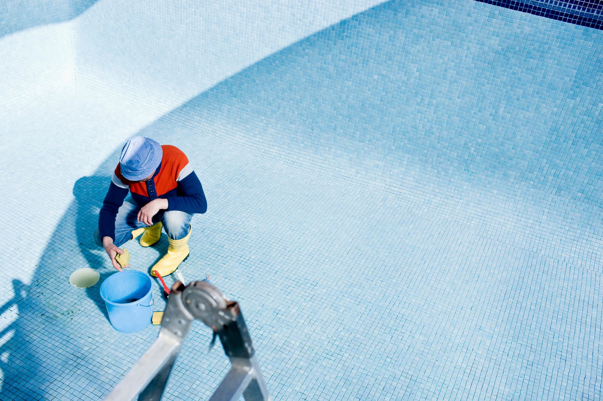 Man cleaning tiled pool